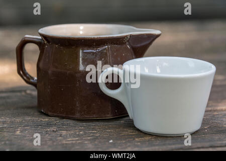 Coppa del bianco e del marrone bricco per il latte Foto Stock