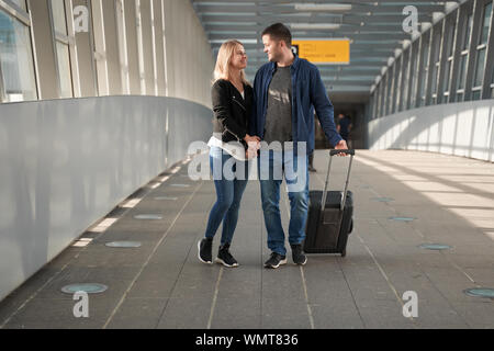 Foto a lato di Felice l uomo e la donna in una fase di transizione in aeroporto Foto Stock