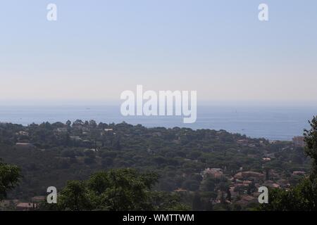 Foto aerea di alberi e costruzione vicino al mare con un cielo limpido sullo sfondo Foto Stock