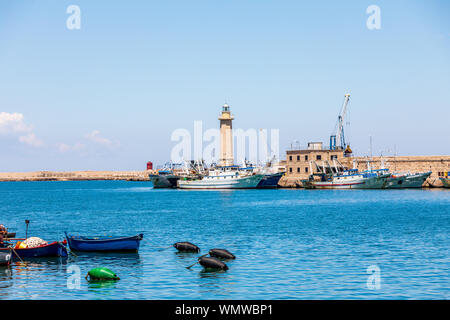 L'Italia, Puglia, Città Metropolitana di Bari, Molfetta. Barche da pesca e del faro. Foto Stock