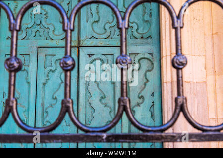 L'Italia, Puglia, provincia di Barletta-Andria-Trani, Trani. Cancellata in ferro battuto e porte blu. Foto Stock