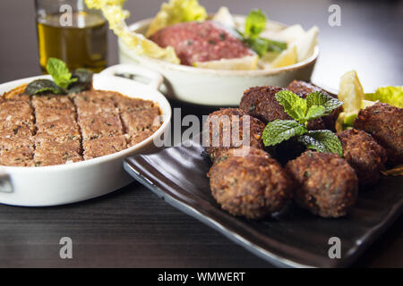 Kibbeh Lbanese cibo fatto di finemente macinati pasta di bulgur, cipolle e carne di agnello o di manzo spezie e foglie di menta piperita. Raw, profondo fritto o grigliato. Traditio Foto Stock