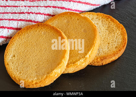 Tre piccoli Crisp cuoce appena fuori dal forno su di un nero slated vassoio Foto Stock