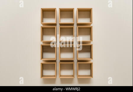 Slick quadrato in legno libro scaffali su un claen sfondo beige Foto Stock