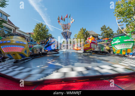 Fiera di fantasia con grande rotonda che gira veloce di sole in una giornata di sole Foto Stock