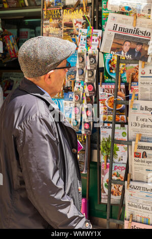 In Italia, Basilicata, provincia di Matera, Matera. Maggio 28, 2019. Uomo che guarda a quotidiani e riviste in Edicola. Foto Stock