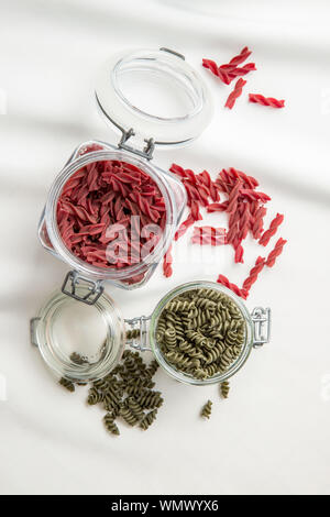 Non cotte pasta colorata con la barbabietola e sapore di spinaci in vaso. Vista dall'alto. Foto Stock