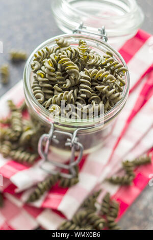 Non cotte pasta colorata con sapore di spinaci in vaso. Foto Stock