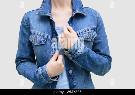 Ragazza caucasica in denim blu con camicia di close-up su sfondo grigio. Foto Stock