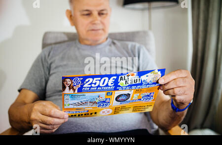 Parigi, Francia - 22 Maggio 2019: Senior grave uomo azienda flyer pubblicità che presentano sul coperchio di più prodotti domestici offerti da esperti Oehler - 4k TV Imposta , macchine di lavaggio Foto Stock