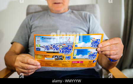 Parigi, Francia - 22 Maggio 2019: Maschio mani lettura flyer pubblicità che presentano sul coperchio di più prodotti domestici offerti da esperti Oehler - 4k TV Imposta , macchine di lavaggio Foto Stock