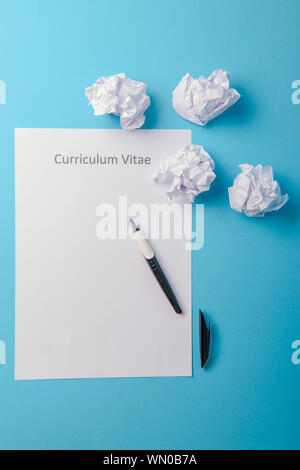 Curriculum vitae scritto su un vuoto di carta bianca su sfondo blu Foto Stock