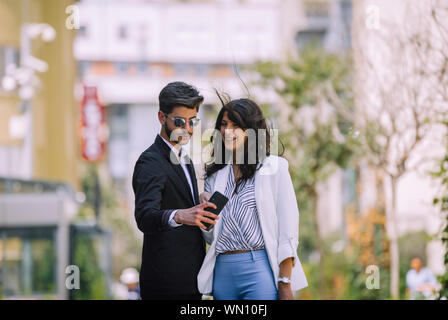 Immagine di uomo bello mentre facendo selfie e bella donna come business partner nel centro cittadino Foto Stock