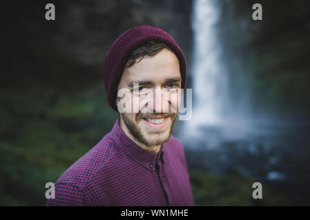 Ritratto di giovane sorridente uomo da Kvernufoss cascata in Islanda Foto Stock