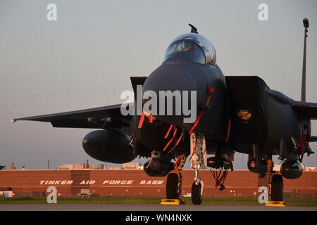 Un F-15E Strike Eagle si crogiola nel tardo luce della sera dopo la fuga uragano Dorian il percorso e il riposizionamento di Tinker Air Force Base in Oklahoma, Sett. 4, 2019. F-15E viene assegnato al 4° Fighter Wing, Seymour-Johnson AFB, North Carolina, come parte del combattimento aereo il comando. Team Tinker eseguito un accordo esistente con Seymour-Johnson AFB, North Carolina e Warner-Robins AFB, Georgia per ospitare i combattenti, petroliere e aerei di ricognizione lontano dal devastante uragano che influiscono sulla costa est degli Stati Uniti. (U.S. Air Force foto/Greg L. Davis) Foto Stock