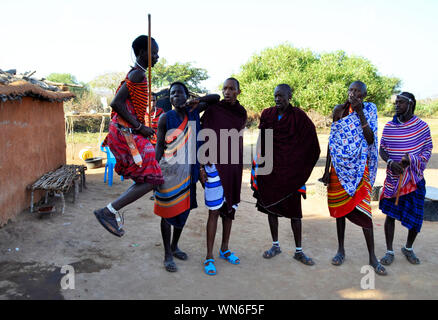 Masai Mara / Kenya, Africa - 25 gennaio, 2018: Masais spiegando le loro tradizioni ai turisti, uno di loro danze tradizionali di salti. Foto Stock