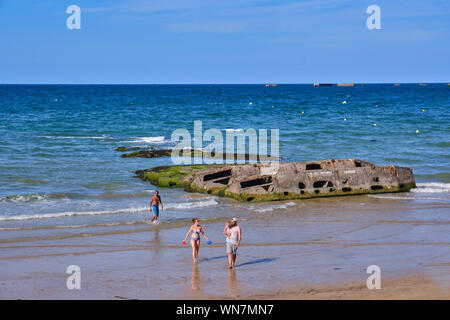 Alcune persone sulla spiaggia di fronte a una parte della porta mullberry porto artificiale. Foto Stock
