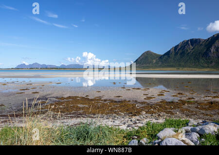 La riflessione di nuvole e le montagne in acqua a Grunnfør su Austvagoy nel nord Lofoten, Norvegia Foto Stock