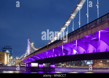 Krymsky Bridge o ponte di Crimea a Mosca, Russia vista notturna con illuminazione viola, acciaio sospensione ponte sul fiume di Mosca alla sera Foto Stock