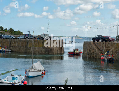 Ingresso al porto Mousehole e St Michael's Mount in distanza . Cornovaglia, England, Regno Unito Foto Stock