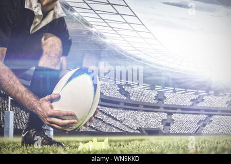 Immagine composita dei maschi di giocatore di rugby immissione rugby palla su un supporto nello stadio Foto Stock