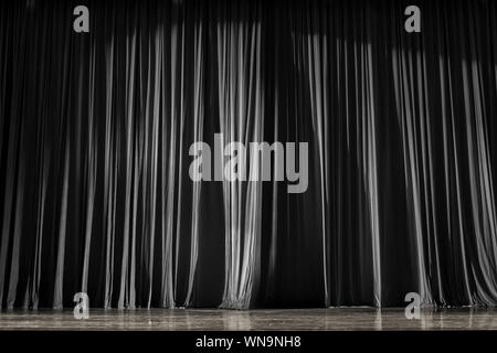 In bianco e nero di tende e di palcoscenico in legno in un teatro. Foto Stock
