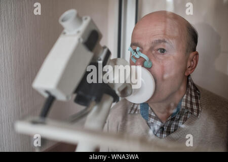 Senior ispanico uomo uomo test funzione di respirazione da spirometria. Diagnosi della funzione respiratoria in malattia polmonare Foto Stock