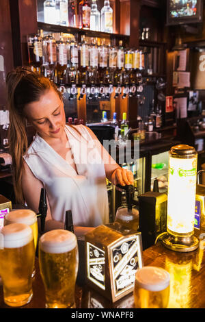 Inghilterra, Londra, Southwark, Bermondsey, barista nel tassello tocca Sam Smiths Pub Foto Stock