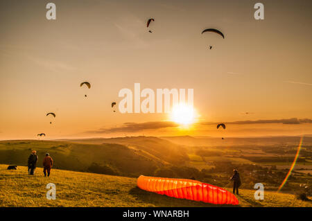 Devils Dyke, Brighton, Sussex, UK..5th Settembre 2019..North Westerley Wind porta piloti di parapendio al popolare sito a nord di Brighton nella bella South Downs. Volare intorno al tramonto ha creato spettacolari scene d'atmosfera. . Foto Stock