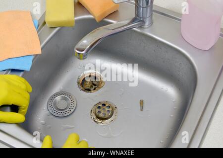 Argenteo lavello da cucina con un smontaggio filtro protettivo. Lavello da cucina il processo di riparazione Foto Stock