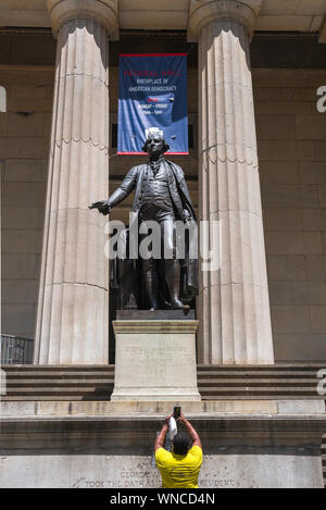 George Washington statua, in vista di un turista di scattare una foto del George Washington statua fuori Federal Hall di Wall Street, Manhattan NYC, STATI UNITI D'AMERICA Foto Stock