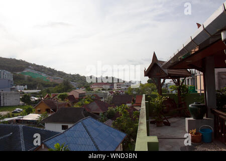 Vista panoramica sul villaggio dei tetti di case dalla terrazza con oscillazione in legno da banco e vaso in Phuket, Tailandia Foto Stock