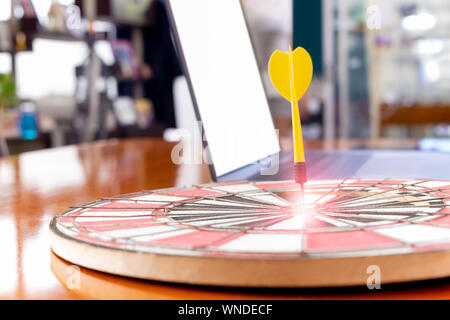 Imposta obiettivo e il successo di lavoro dart gialli freccia con il laptop in background. Foto Stock