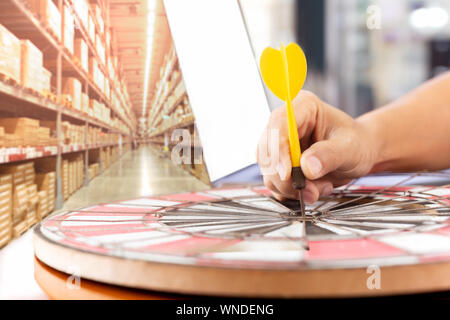 Dart gialli freccia con laptop e factory store warehouse in background. Foto Stock