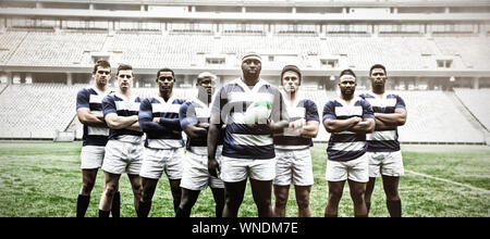 Gruppo di maschi diversi giocatori di rugby assieme con palla da rugby in stadium Foto Stock