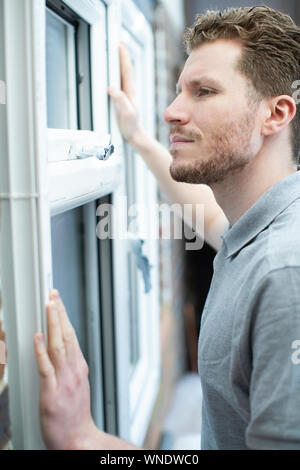 Operaio edile Installazione di nuove finestre in casa Foto Stock