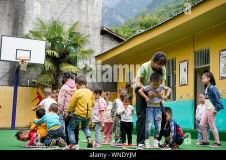 (190906) -- CHONGQING, Sett. 6, 2019 (Xinhua) -- Professore Tao Yao organizza gli studenti per la riproduzione a Lianhua scuola primaria di Luzi Village, Chengkou County, a sud-ovest della Cina di Municipalità di Chongqing, Sett. 3, 2019. Mu Yi, un 25-anno-vecchio insegnante PE dalla Municipalità di Chongqing, offre una settimana di volontariato servizio di insegnamento e le opere di un maestro locale Tao Yao in questo remoto villaggio. Nella scuola dove solo due di secondo grado studenti e 18 bambini di età prescolare studio, Mu Yi e Tao Yao anche fare altri lavori come mandanti, detergenti, i cuochi e repairwomen. Mu Yi insegna ai bambini sport, arte e musica e tel Foto Stock