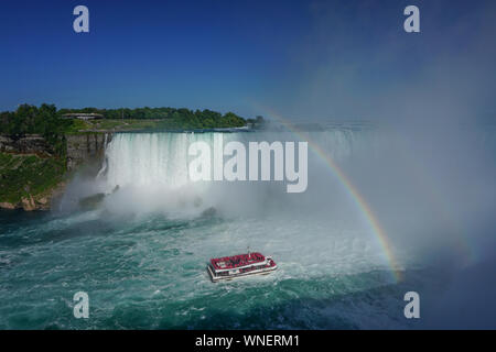 Niagara Falls, Ontario, Canada: un doppio arcobaleno appare sopra il fiume Niagara come un tour in barca porta i visitatori fino ai piedi delle cascate Horseshoe. Foto Stock