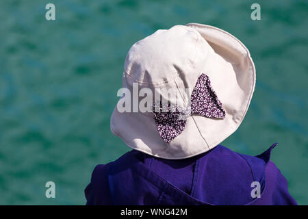 Donna che indossa cappello da sole al Bournemouth Air Festival, Dorset UK nel mese di agosto Foto Stock