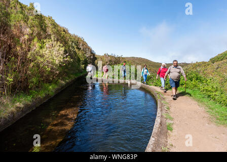 I turisti a piedi una su un percorso guidato di levada a piedi a Madeira Foto Stock