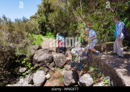 I turisti a piedi una su un percorso guidato di levada a piedi a Madeira Foto Stock