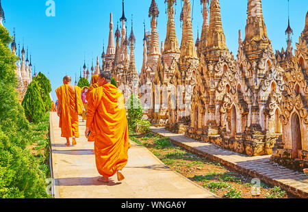 KAKKU, MYANMAR - Febbraio 20, 2018: i monaci Bhikkhu a piedi lungo il sentiero in Kakku pagode complesso, circondato da riccamente decorate stupa, su Febr Foto Stock