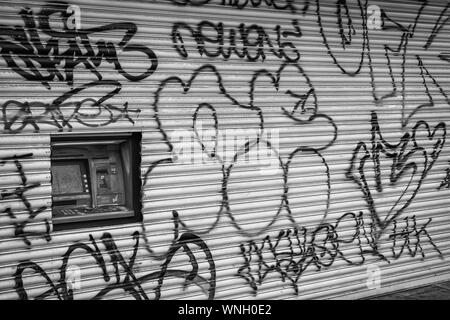 London Road, Brighton Regno Unito 09/06/2019 Graffiti sul negozio di ante con foro per danneggiato bancomat Foto Stock