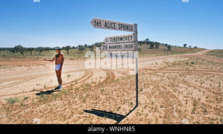 Il dipendente di una remoe pecore stazione nel Territorio del Nord Entroterra Australiano hitchhikes torna alla sede da un giorno a visitare un amico su Foto Stock