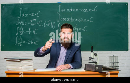 Ottenere al di fuori della classe. Insegnante severo grave uomo barbuto lavagna sfondo. Insegnante guarda minacciosa. Regole di comportamento scolastico. Scuola principale minaccia di punizione. Maestro esigente. Foto Stock