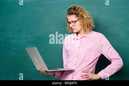 Studio online. Stelo dello studente. Insegnare il corso on-line. Informatica e di programmazione. Scuola Online. Remote job. Notebook insegnante nella ricerca di informazioni di sfondo lavagna. Donna laptop navigare in internet. Foto Stock
