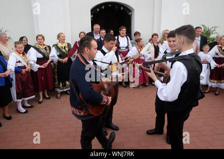 La gente di cantare e ballare dopo la Messa per la Giornata del Ringraziamento in Stitar, Croazia Foto Stock