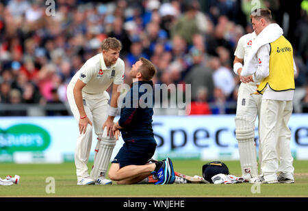 Inghilterra è Joe Root riceve un trattamento medico dopo essere stato colpito dalla sfera durante il giorno e tre la quarta prova di ceneri a Emirates Old Trafford, Manchester. Foto Stock