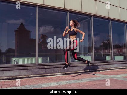 Conciate donna, istruttori di fitness è il salto ragazza atleta è jogging di mattina e in estate città, bella atleta è impegnato nel fitness, gioventù Foto Stock