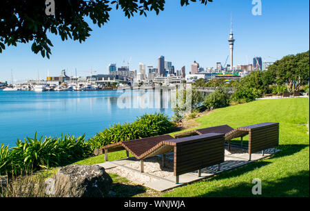 Panche di legno in Waterfront Park (vicino al porto), con una splendida vista del centro cittadino di Auckland - Auckland, Nuova Zelanda Foto Stock